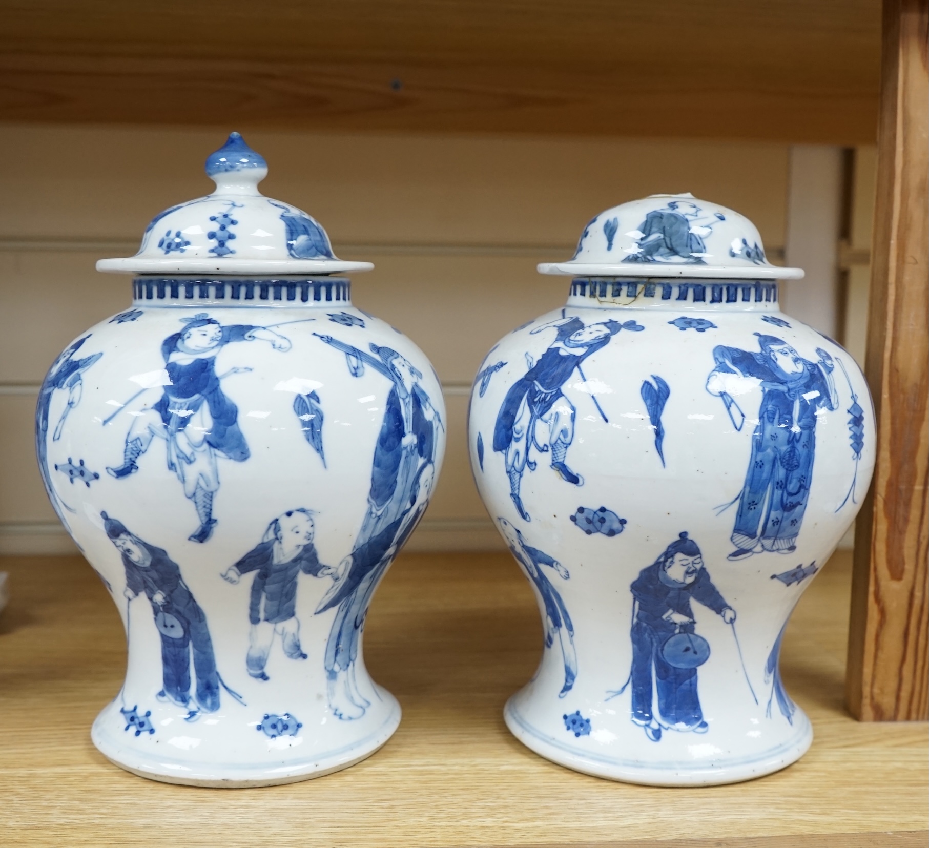 A pair of Chinese blue and white ‘street performers’ baluster vases, circa 1900, 25cm. 25.5cm. Condition - damaged